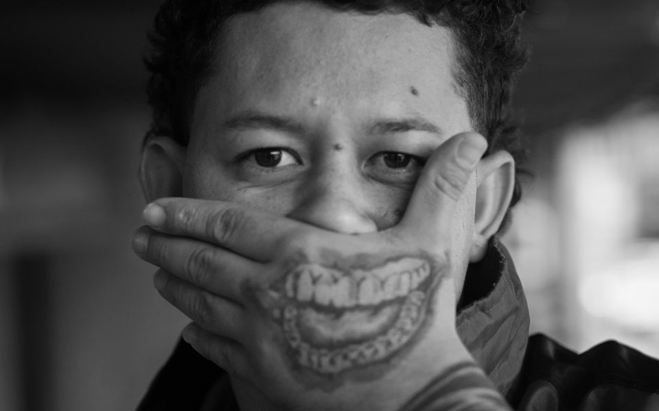 El actor guatemalteco Rudy Rodríguez, quien encarna a Andrés en la película Cadejo Blanco (2021), un thriller sobre las pandillas en Guatemala, se intercambia el rostro con esta sonrisa tatuada en su mano.