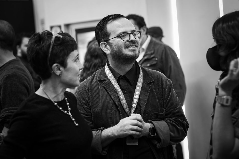 El cineasta costarricense Nicolás Pacheco espera (ansioso con su gafete en mano) el estreno de su largometraje La pasión de Nella Barrantes, que se proyectó en el Cine Magaly en horas de la tarde. La película fue seleccionada en la Competencia centroamericana y caribeña de largometrajes del 10CRFIC